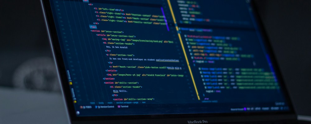 Developer writing code on a laptop for a mobile app